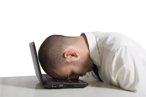 Frustrated? Man with head on computer